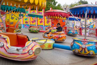 baba ve kızı lunaparkta atlıkarınca üzerinde dönen