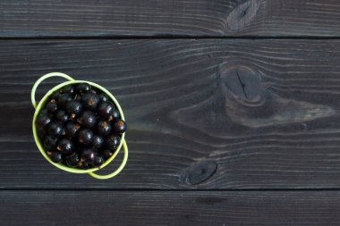 Tahta arka plandaki kasede taze kuşüzümü var. en üstteki görünüm