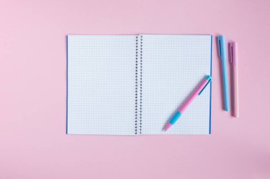 Pembe arka planda okul defteri ve kırtasiye malzemesi. Okul konseptine dönelim.