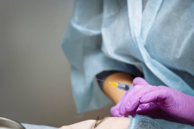 Güzel genç kadın bir gençleştirici yüz enjeksiyonları alıyor. Güzellik hyaluronik asit tarafından kadın kırışıklıkları dolduruyor. Güzellik salonunda genç bir kadın. Kozmetoloji Cilt Bakımı.