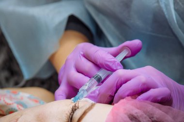 Güzel genç kadın bir gençleştirici yüz enjeksiyonları alıyor. Güzellik hyaluronik asit tarafından kadın kırışıklıkları dolduruyor. Güzellik salonunda genç bir kadın. Kozmetoloji Cilt Bakımı.