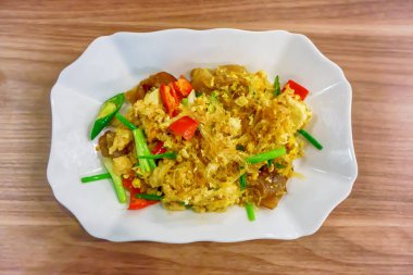 Kızarmış şehriye ahşap zemin üzerinde beyaz tabak.