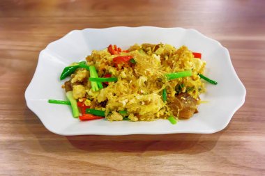 Kızarmış şehriye ahşap zemin üzerinde beyaz tabak.