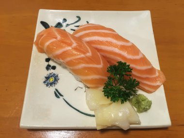 Ahşap masa tabağa somon suşi. Suşi yemek hazırlama Japonya'da kaynaklanan bir türüdür.