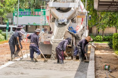 Yol yapmak için çimento dökerek inşaat işçisi.