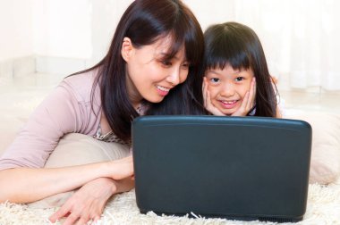 Asya anne ve kızı dizüstü evde kullanma