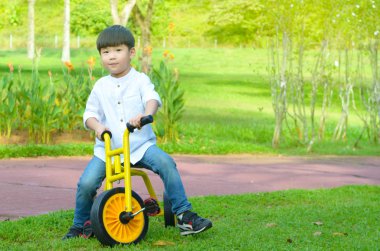 Güzel Asyalı çocuk parkta Bisiklete binme