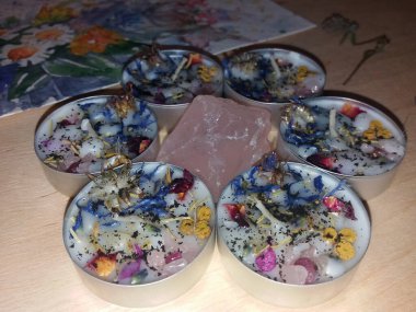 Homemade tea lights with crystals, dried herbs and flowers to attract love and fidelity clipart