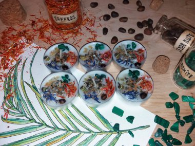 Homemade tea lights with crystals, dried herbs and flowers to attract money and good fortune clipart