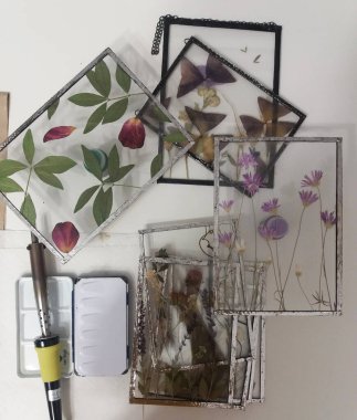 Renkli camdaki Tiffany tekniğinde çerçevelenmiş baskılı çiçekler.