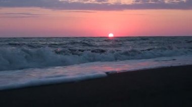 Plajda inanılmaz güzel kırmızı günbatımı pembe günbatımı deniz dalgaları, cennet deniz manzarası güneş dokunuşlar parlıyor ışık demeti Waters Edge renkler. 30 kare/sn