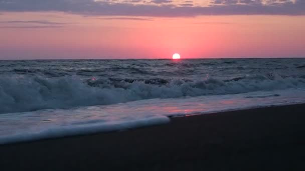 Beau coucher de soleil rouge à la plage Couleurs étonnantes faisceau de lumière brillant à travers le paysage marin nuageux au coucher de soleil rose Vagues de mer Soleil touche le bord des eaux. 30 ips — Video