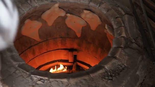 Traditionelle Bäckerei Ton oder Torne oder Turne zum Backen eines georgischen Shotis Puri oder Shoti Brot. Garprozess: Bäcker formt das Fladenbrot und klebt Teig an Backofenwand und nimmt fertige Shoti in — Stockvideo