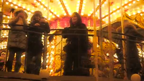 Moszkva - 2017. December 25.: Emberek a körhinta a közelben Vörös tér díszített, és elhelyezni a karácsonyi Szilveszter. Karácsonyi vásár. Világító körforgalom forog a felnőttek és a gyermekek — Stock videók