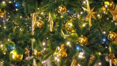 Odak arka plan dışarı ile gece ışıltılı bir Noel ağacı ışıkları kapatın. Dekorasyon ve aydınlatma ile yeni yıl ağacı. Xmas ağacı süslemeleri arka plan