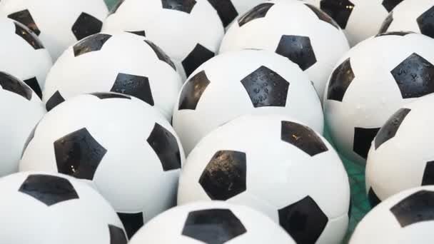 Muchas bolas de fútbol blanco y negro de fondo. Pelotas de fútbol nadando en un agua pura — Vídeos de Stock