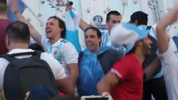 MOSCOW, RÚSSIA, JUNHO 20, 2018: Copa do Mundo de Futebol torcedores de futebol argentinos em bonés com símbolos da equipe nacional com bandeiras no em Nikolskaya Street pulando canções cantando, uma multidão com celular — Vídeo de Stock