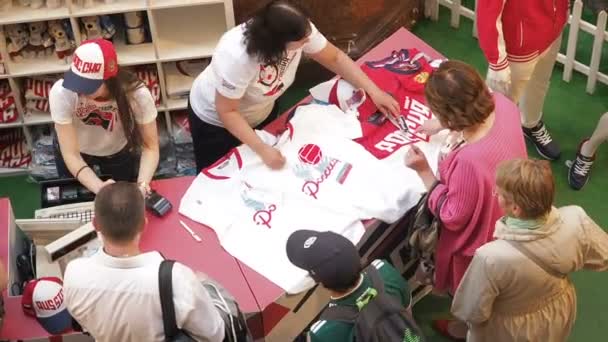 MOSCOW, RÚSSIA - AGOSTO 5, 2018: Turistas compram uniformes oficiais de jogador de futebol como lembranças no ponto de venda de loja de esportes em GUM, Moscou . — Vídeo de Stock