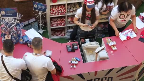 MOSCÚ, RUSIA - 5 de agosto de 2018: Los turistas compran recuerdos oficiales en el punto de venta de la tienda de deportes en GUM, Moscú. El video fue tomado desde arriba — Vídeos de Stock