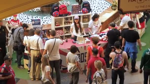 Moskou, Rusland -, 5 augustus 2018: Toeristen kopen official hockey speler uniformen als souvenir in het punt van verkoop van sport winkel in het tandvlees is gebroken, Moskou. Video werd genomen van bovenaf — Stockvideo