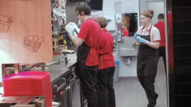 Moskova, Rusya - 16 Eylül 2018: Erkekler ve kadınlar inşaat Mutfak Fast Food Restoran zinciri içinde. McDonalds mutfak personeli çalışma sürecinde. İş akışı Mutfak Fast Food Cafe