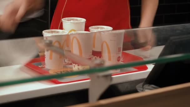 Moskow, Rusia - 16 September 2018: Manajer di McDonalds bersiap-siap untuk memberikan nampan dengan perintah kepada klien. Karyawan McDonalds bekerja dengan makanan disajikan di atas nampan. Tampilan tertutup, plastik — Stok Video