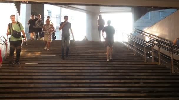 Mosca, Russia - 6 settembre 2018: La gente comune sale e scende alla metropolitana sotterranea all'ora di punta. La gente scende al sottopassaggio. Silhouette di persone che scendono le scale contro il — Video Stock