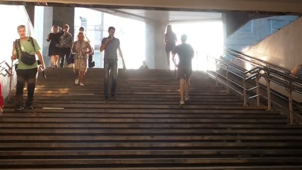 Moscou, Russie - 6 septembre 2018 : Des gens ordinaires montent et descendent dans le métro souterrain à l'heure de pointe. Les gens descendent au passage souterrain. Silhouettes de personnes marchant sur les marches contre la — Video