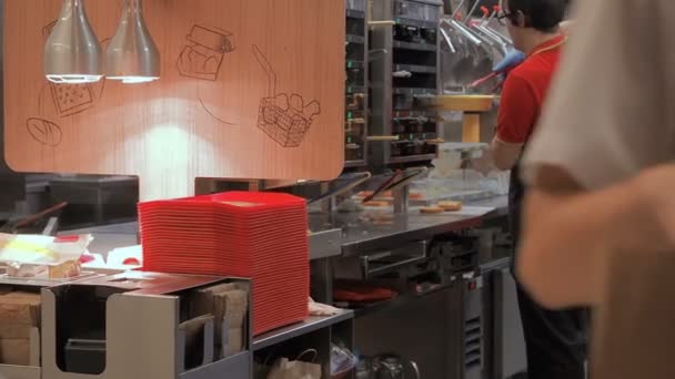 Moscow, Russia - September 16, 2018: Restaurant Worker Packs Hamburgers in Boxes. People The Guy Prepares a Hamburger and Packs it in a Package. Works in the Kitchen Fast Food Restaurant Chain — Stock Video