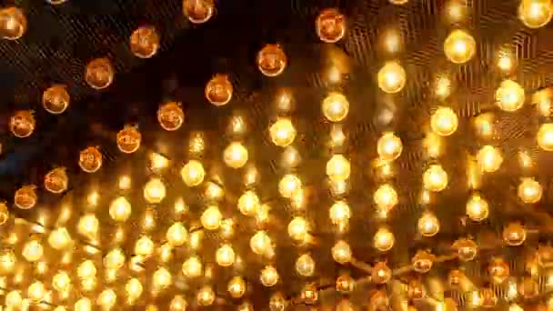 Wiele jasnych świecące lampy ze szkła. Zestaw oświetleniowy z Edison lampy retro na tle ciemnego siatka druciana. Modne loft design z modne loft design z żarówki Edison. Abstrakcja przemysłowe — Wideo stockowe