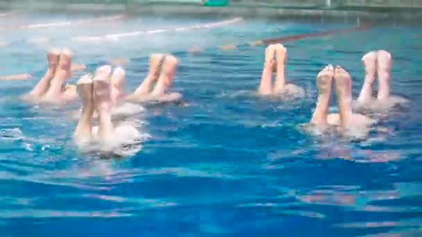 Synchroonzwemmen. Slanke benen meisjes atleten stok uit het water in open zwembad in de winter. Jonge meisjes leren zwemmen in het zwembad. Jonge meisjes zijn opgeleid om wedstrijdzwemmen in het zwembad — Stockvideo