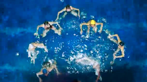 Συγχρονισμένη κολύμβηση. Νεαρά κορίτσια μαθαίνουν κολύμπι στην πισίνα. Νεαρά κορίτσια εκπαιδεύονται σε ανταγωνιστική κολύμβηση στην πισίνα. Ομαδικά αθλήματα νερού, κορίτσια συγχρονισμένη κολύμβηση — Αρχείο Βίντεο