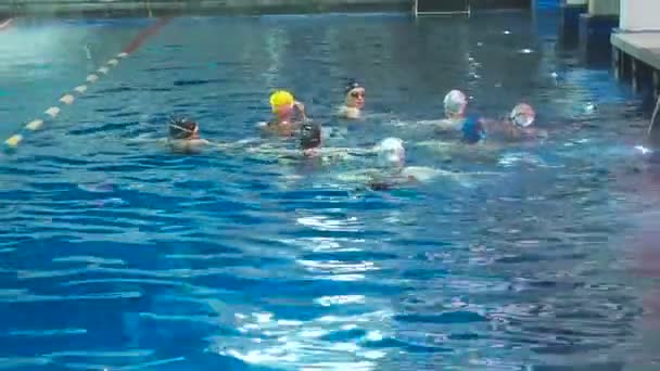 Natación sincronizada. Chicas piernas delgadas atletas sobresalen del agua en la piscina abierta en invierno. Las chicas jóvenes aprenden a nadar en la piscina. Las chicas jóvenes están entrenadas para nadar en la piscina — Vídeos de Stock