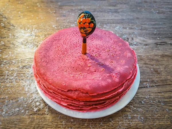 Kırmızı pancar krep bir tahta kaşık deldi. Shrovetide Maslenitsa tereyağı hafta Festivali yemek. Rus gözleme Bliny rustik ahşap arka plan üzerinde yığını kar ile serpilir. Üst yan görünüm