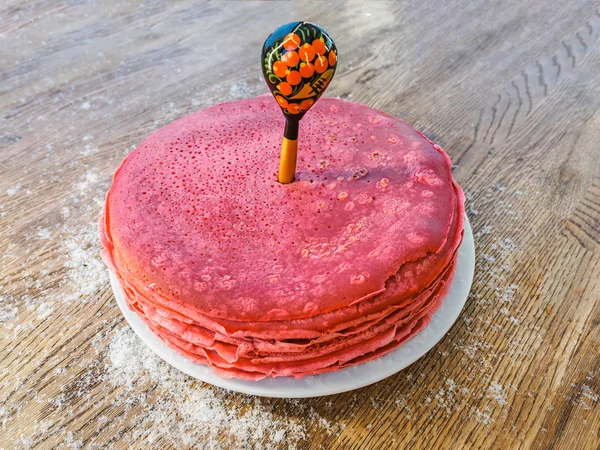 Kırmızı pancar krep bir tahta kaşık deldi. Shrovetide Maslenitsa tereyağı hafta Festivali yemek. Rus gözleme Bliny rustik ahşap arka plan üzerinde yığını kar ile serpilir. Üst yan görünüm