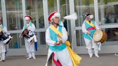 Moskova, Rusya, 12 Temmuz 2018: Kore Kültür Festivali. Müzisyenler ve dansçılar parlak renkli elbiseli bir grup geleneksel Güney Kore halk dansları Samul nori Samullori veya Pungmul gerçekleştirmek ve oyun