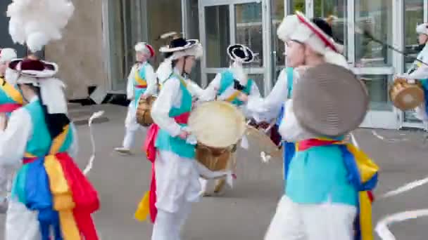 Moskou, Rusland, 12 juli 2018: Koreaanse cultuurfestival. Een groep muzikanten en dansers in fel gekleurde kostuums voeren traditionele Zuid-Koreaanse volksdans Samul nori Samullori of Pungmul en spelen — Stockvideo