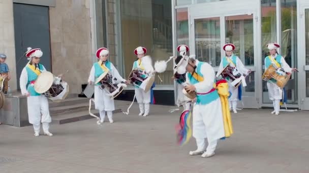 Moscú, Rusia, 12 de julio de 2018: Festival de cultura coreana. Un grupo de músicos y bailarines en trajes de colores brillantes realizan danza folclórica tradicional surcoreana Samul nori Samullori o Pungmul y juegan — Vídeo de stock