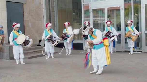 Moscú, Rusia, 12 de julio de 2018: Festival de cultura coreana. Un grupo de músicos y bailarines en trajes de colores brillantes realizan danza folclórica tradicional surcoreana Samul nori Samullori o Pungmul y juegan — Vídeos de Stock