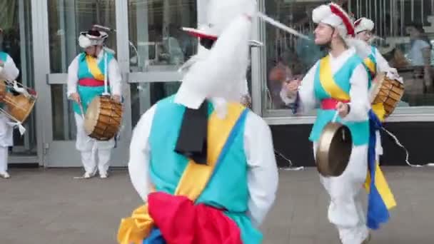 Moskou, Rusland, 12 juli 2018: Koreaanse cultuurfestival. Een groep muzikanten en dansers in fel gekleurde kostuums voeren traditionele Zuid-Koreaanse volksdans Samul nori Samullori of Pungmul en spelen — Stockvideo