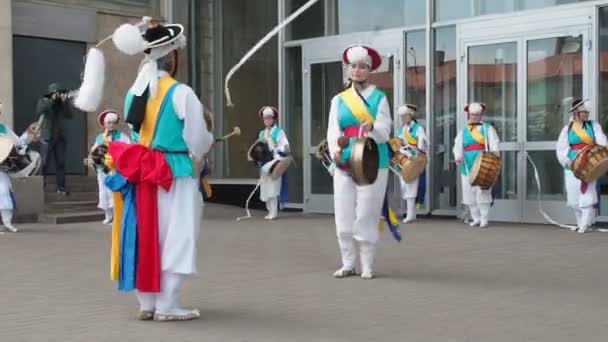 Moskou, Rusland, 12 juli 2018: Koreaanse cultuurfestival. Een groep muzikanten en dansers in fel gekleurde kostuums voeren traditionele Zuid-Koreaanse volksdans Samul nori Samullori of Pungmul en spelen — Stockvideo