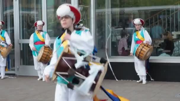 Moscou, Rússia, 12 de julho de 2018: festival de cultura coreana. Um grupo de músicos e dançarinos em ternos coloridos brilhantes executar tradicional dança folclórica sul-coreana Samul nori Samullori ou Pungmul e jogar — Vídeo de Stock