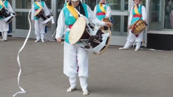 Moskva, Ryssland, 12 juli 2018: Koreansk kulturfestival. En grupp av musiker och dansare i ljusa färgade kostymer utför traditionella sydkoreanska folkdans Samul nori Samullori eller Pungmul och spela — Stockvideo