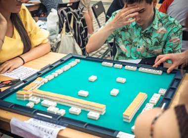 Moskova, Rusya - 09 Ağustos 2018: Japon Festivali, Moskova. Asya kiremit tabanlı oyun Mahjong oynamaya gençler. Tablo kumar yan görünümü