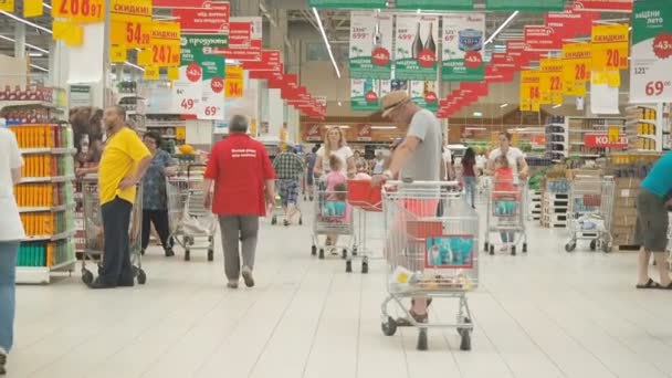 MOSCOU 29 SEPTEMBRE 2018 : Différentes personnes traversent le supermarché avec des chariots. Les mamans avec des enfants faisant du shopping dans les chariots. Les gens font des achats dans l'hypermarché Ashan . — Video