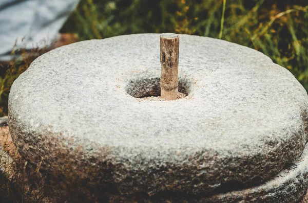 Древняя каменная ручная мельница с зерном. Средневековая ручная мельничная пшеница. Старая каменная мельница с зерном . — стоковое фото