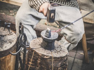 Demirci Açıkhava atölye el yapımı metal ürünleri üretim süreci. Demirci, metal bir çekiçle vurur. Elinde bir demirci kızgın demir çubuk ile yakın çekim