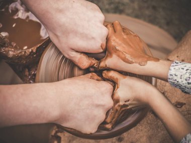 Nasıl toprak kap potters tekerlek üzerinde atmak için gösterilen bir çocuk el rehberlik Seramik A carftmans eller öğretim. Öğretmen ve öğrenci kavram. Üstten görünüm