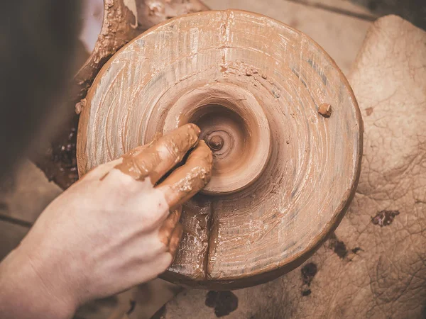 Обертові гончарні колеса і глиняний посуд на ньому взяті зверху. Скульптури руками з глиняною чашкою на гончарному колесі. Руки в глині. Керамічний чоловічий кераміст створює ручний глиняний продукт. Процес створення — стокове фото