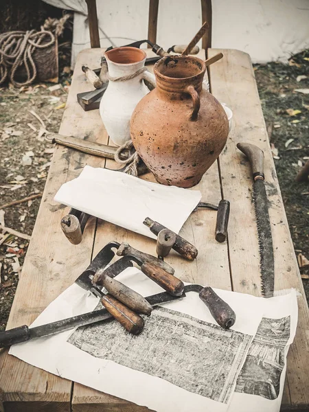 Staré dřeva ruční nástroj Poříz, drawshave, výkresu nůž holicí knifewooden v truhlářské dílně na špinavé rustikální stůl s bočním výhledem na staré hlíny untensils která byla pozadí — Stock fotografie